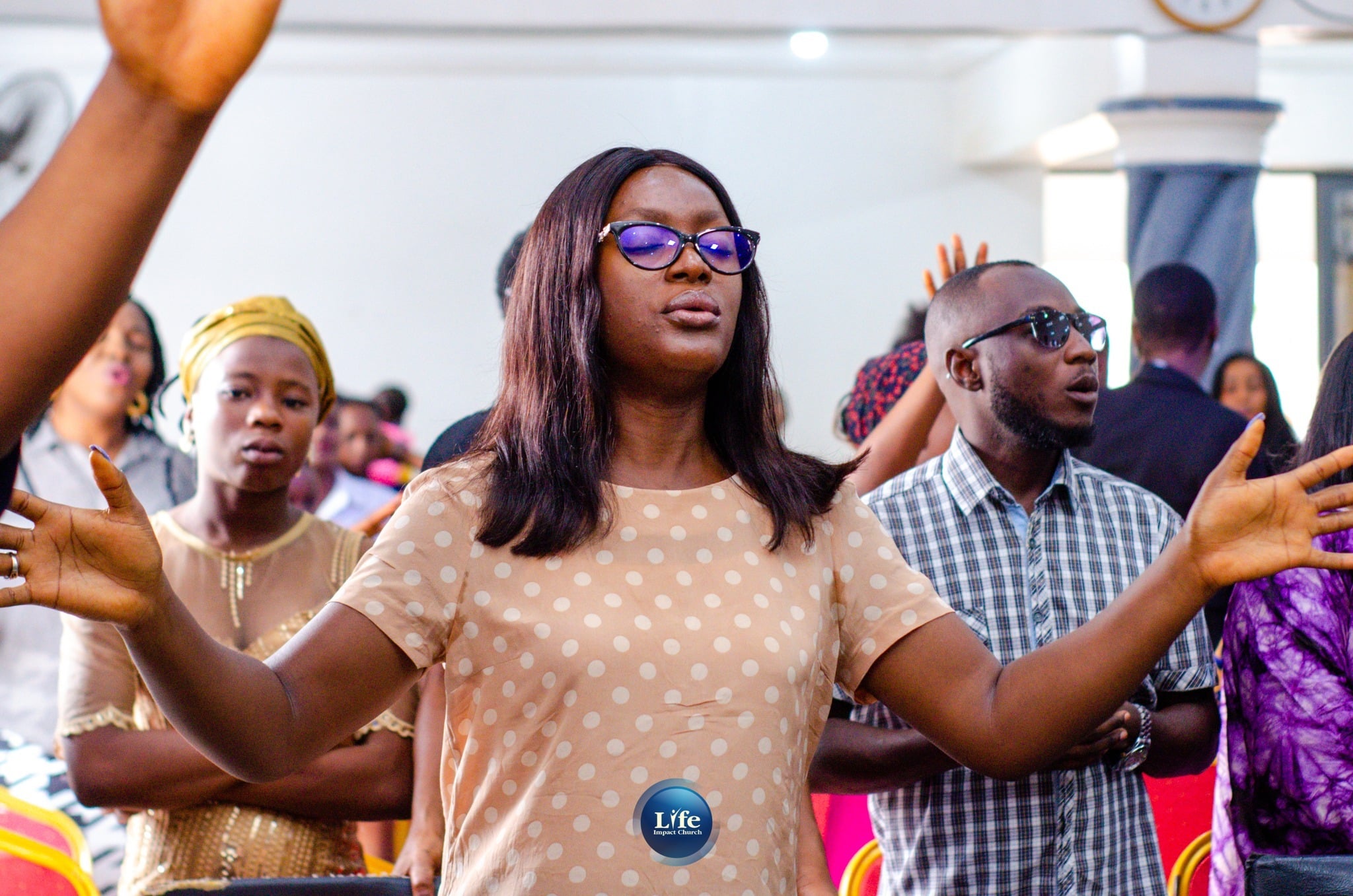 Worshippers with their hands raised on a Sunday