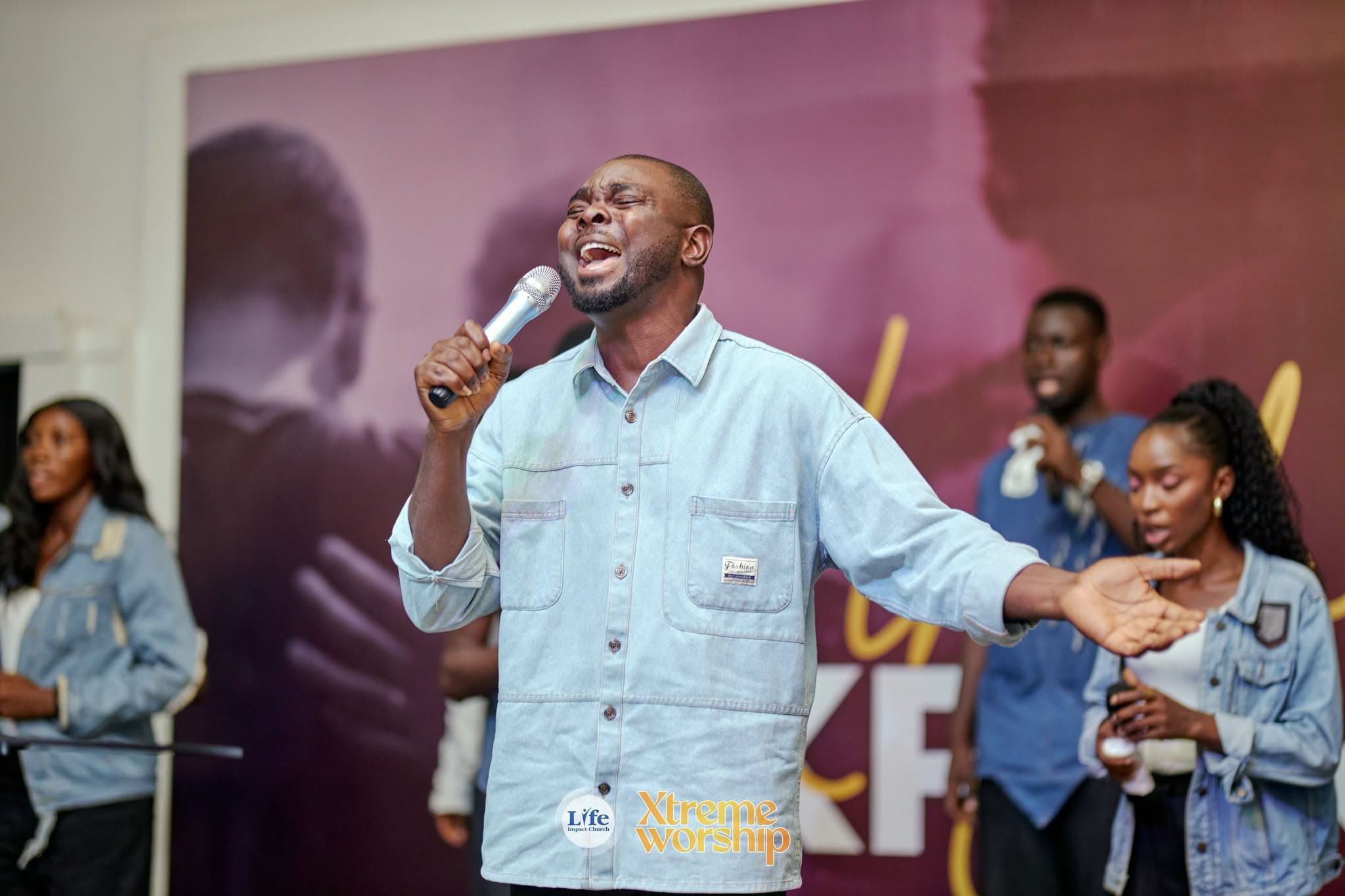 A worship leader with arms open